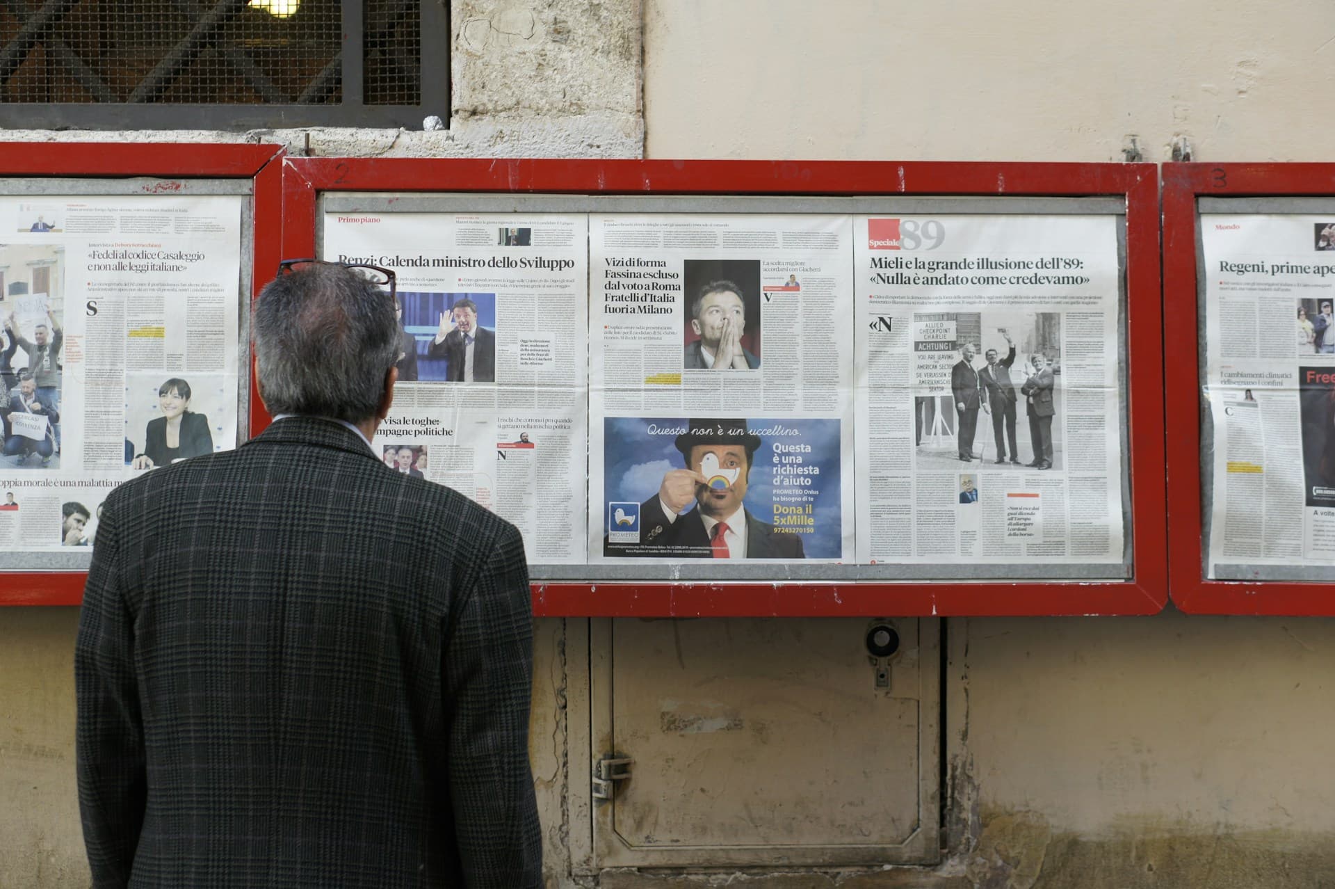 Person looking at a wall of newspapers